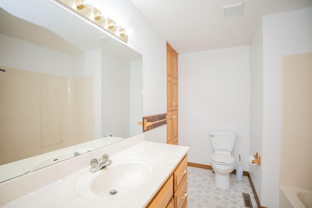 bathroom with vanity, a textured ceiling, and toilet