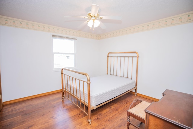 bedroom with ceiling fan and hardwood / wood-style flooring