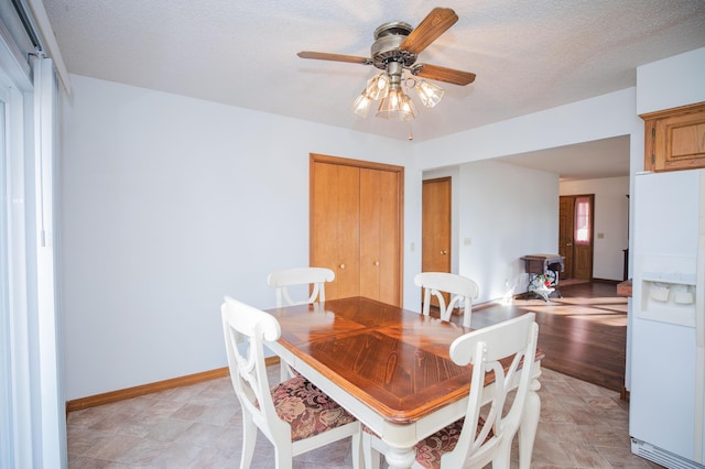 dining space with a textured ceiling and ceiling fan