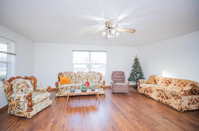 living room with ceiling fan, plenty of natural light, a textured ceiling, and hardwood / wood-style flooring