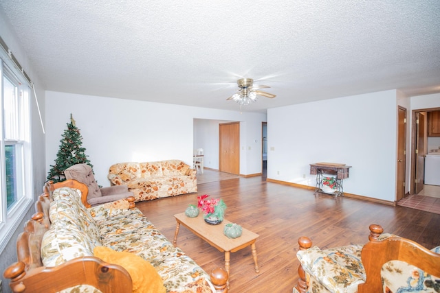 living room featuring ceiling fan, hardwood / wood-style floors, and a textured ceiling