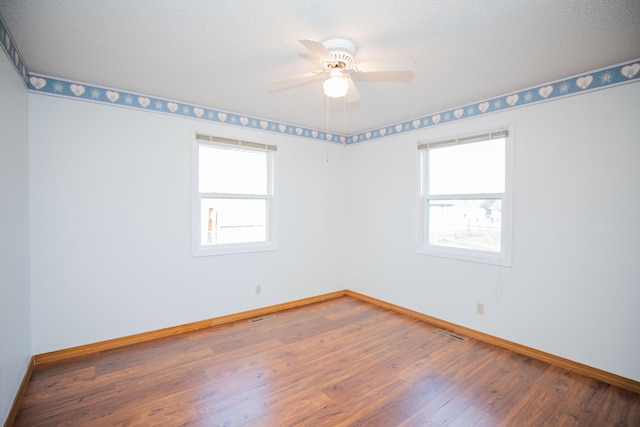 empty room with hardwood / wood-style floors, a textured ceiling, and ceiling fan