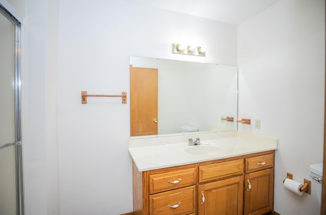 bathroom featuring vanity, toilet, and walk in shower