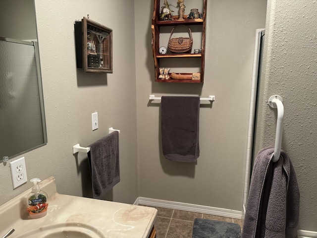 bathroom with tile patterned floors, vanity, and walk in shower