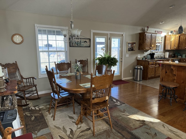 dining space with hardwood / wood-style flooring, sink, a textured ceiling, and an inviting chandelier