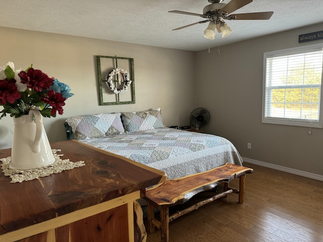 bedroom featuring ceiling fan, a textured ceiling, and hardwood / wood-style flooring