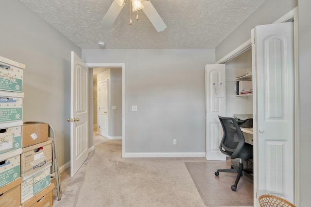 home office with light carpet, a textured ceiling, and ceiling fan