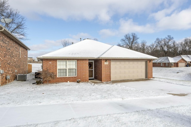 ranch-style home featuring central AC unit and a garage