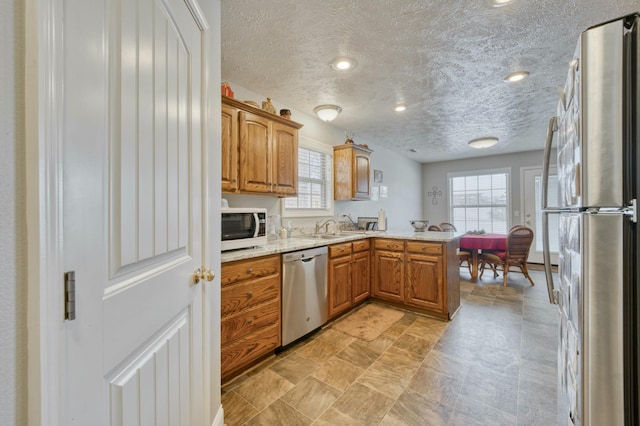 kitchen featuring kitchen peninsula, sink, plenty of natural light, and appliances with stainless steel finishes