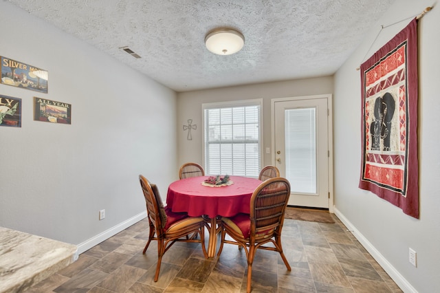 dining space with a textured ceiling