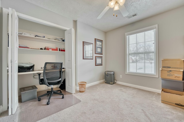 carpeted office with ceiling fan and a textured ceiling