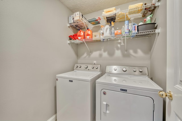 washroom with a textured ceiling and washing machine and clothes dryer