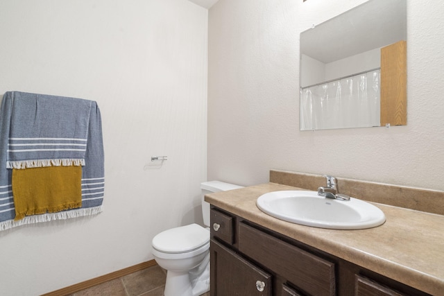 full bathroom with toilet, tile patterned floors, baseboards, and vanity