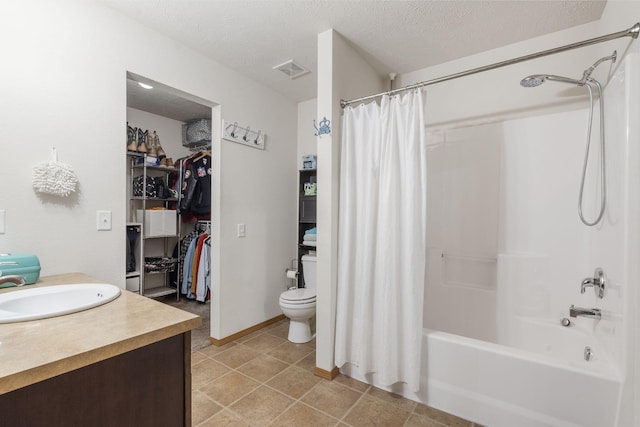 full bath with a walk in closet, shower / tub combo with curtain, visible vents, a textured ceiling, and vanity