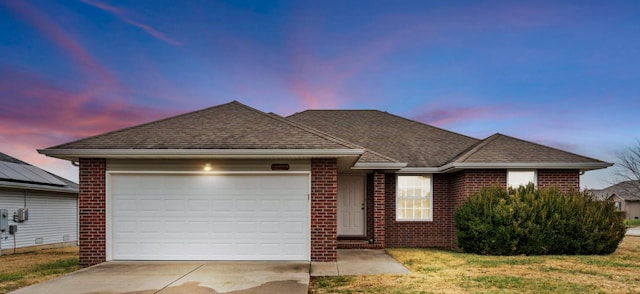 single story home featuring an attached garage, a shingled roof, concrete driveway, and brick siding