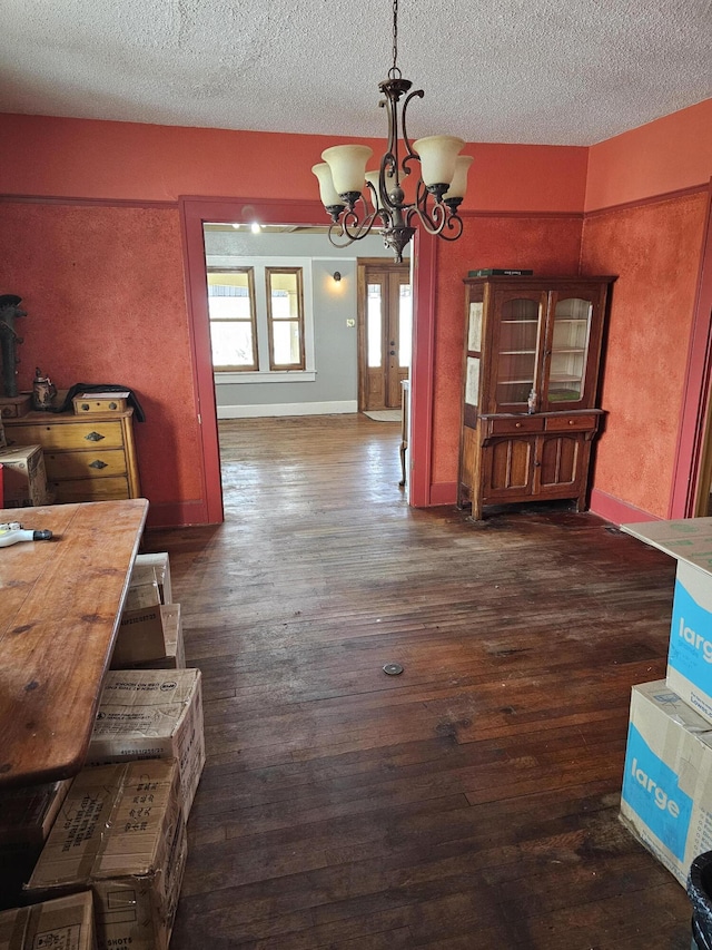 dining room featuring a notable chandelier, a textured ceiling, and dark hardwood / wood-style floors