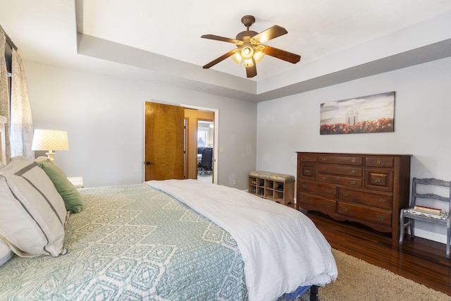 bedroom featuring hardwood / wood-style floors, ceiling fan, and a tray ceiling