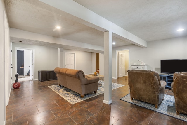 living room featuring a textured ceiling, recessed lighting, and baseboards