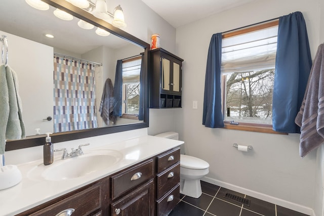 bathroom with visible vents, toilet, vanity, baseboards, and tile patterned floors