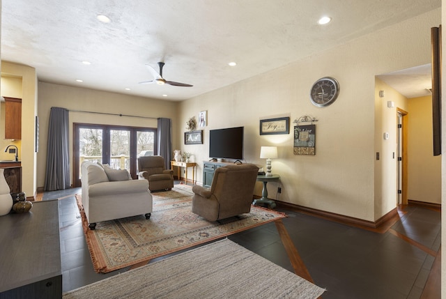 living room featuring ceiling fan, baseboards, and recessed lighting