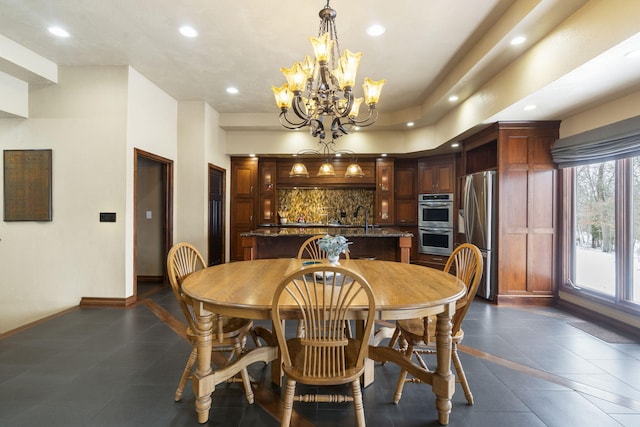 tiled dining area with sink and a chandelier