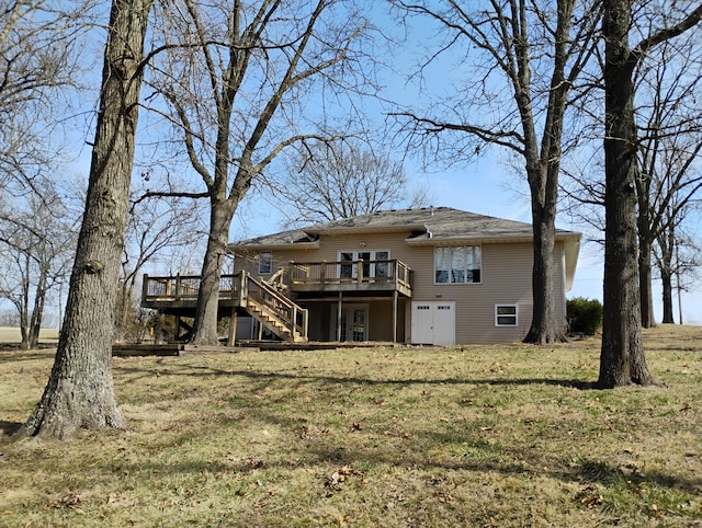 back of house featuring stairway, a deck, and a lawn