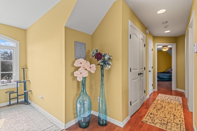hallway featuring baseboards and wood finished floors