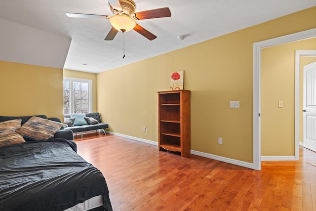 bedroom with a ceiling fan, baseboards, and light wood-style floors
