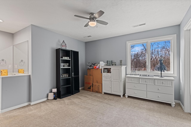 bedroom with visible vents, a ceiling fan, baseboards, and light carpet