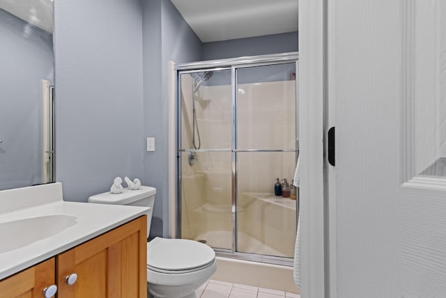 bathroom with vanity, tile patterned floors, a stall shower, and toilet