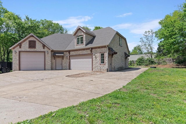 view of front facade with concrete driveway, a front yard, an attached garage, and stone siding