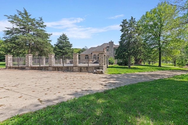 view of property's community featuring a lawn and fence