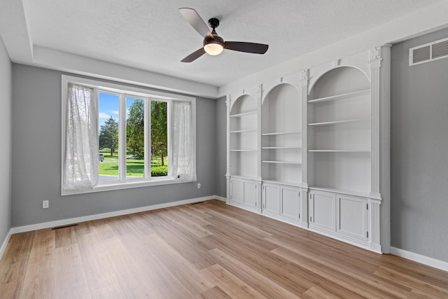 unfurnished room with visible vents, baseboards, a textured ceiling, a ceiling fan, and light wood finished floors