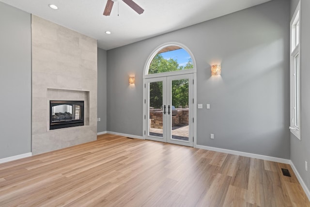 unfurnished living room with visible vents, wood finished floors, recessed lighting, a tile fireplace, and a ceiling fan
