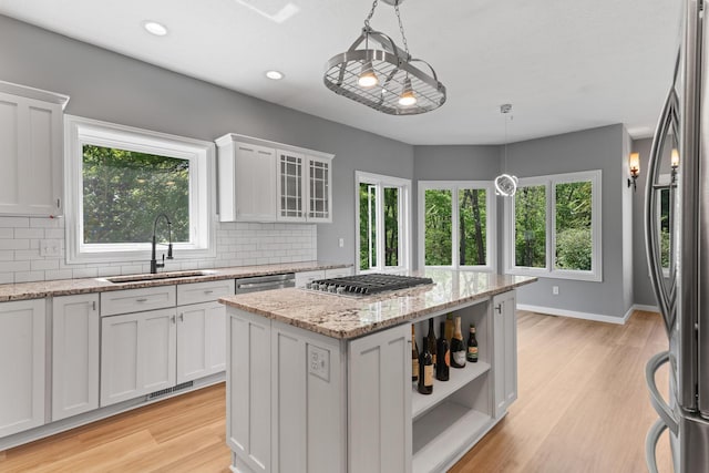 kitchen featuring visible vents, white cabinetry, a sink, backsplash, and stainless steel appliances