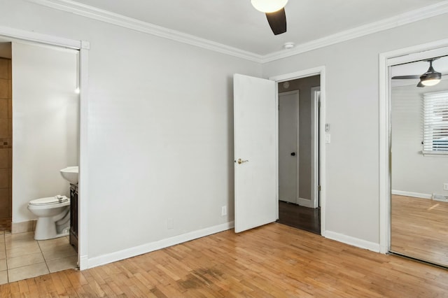 unfurnished bedroom featuring ceiling fan, light hardwood / wood-style floors, ornamental molding, and ensuite bathroom