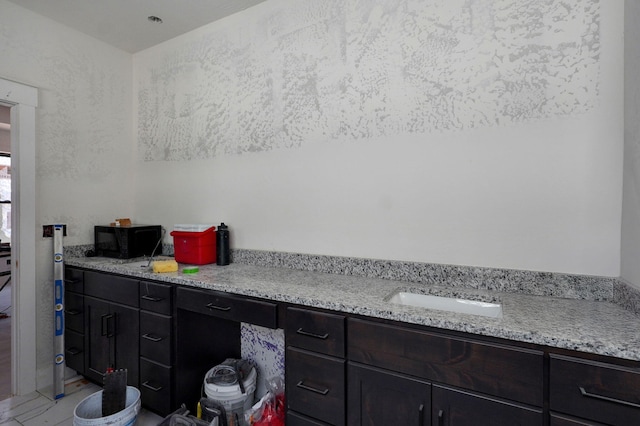 interior space with light stone countertops and sink