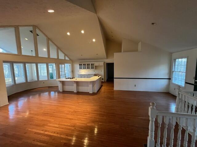 unfurnished living room featuring hardwood / wood-style floors and high vaulted ceiling