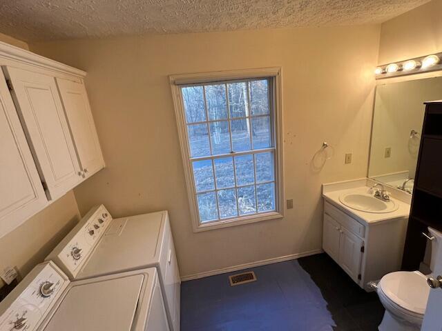 interior space with washer and dryer, a textured ceiling, and sink