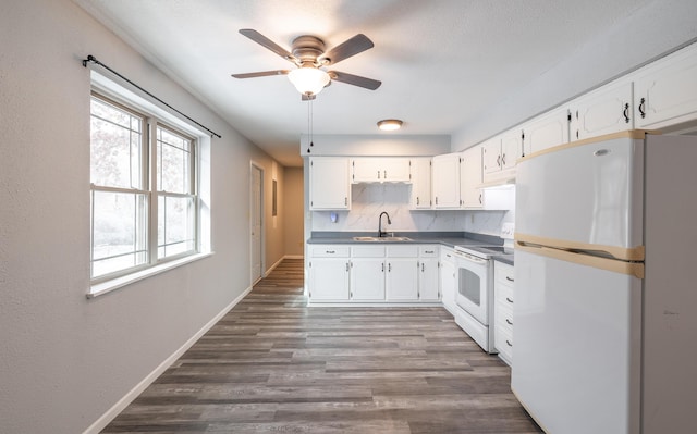 kitchen with decorative backsplash, white appliances, sink, dark hardwood / wood-style floors, and white cabinetry