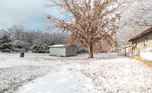 yard covered in snow featuring a shed