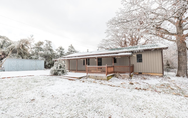 view of front of house featuring covered porch and a storage shed