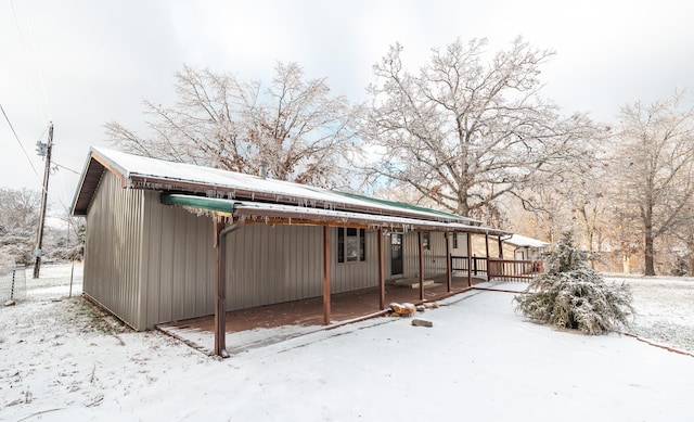 snow covered house featuring a deck