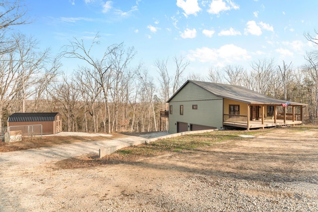 view of side of property with a porch and a shed