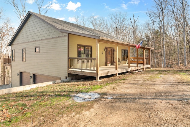 view of home's exterior featuring a deck, a porch, and a garage