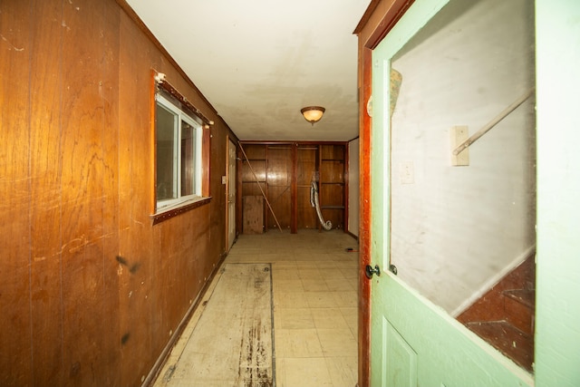 hallway featuring wood walls