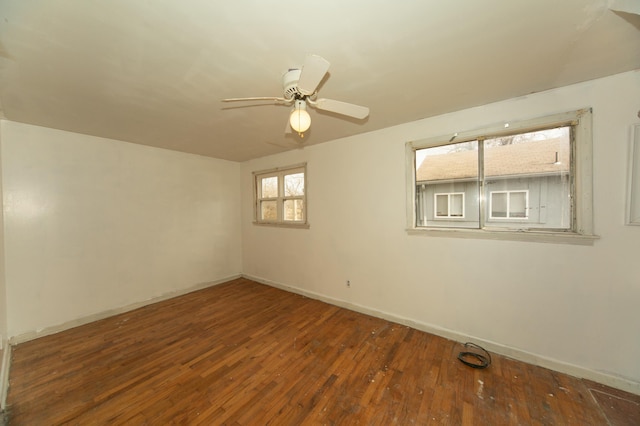 empty room with ceiling fan and dark hardwood / wood-style flooring