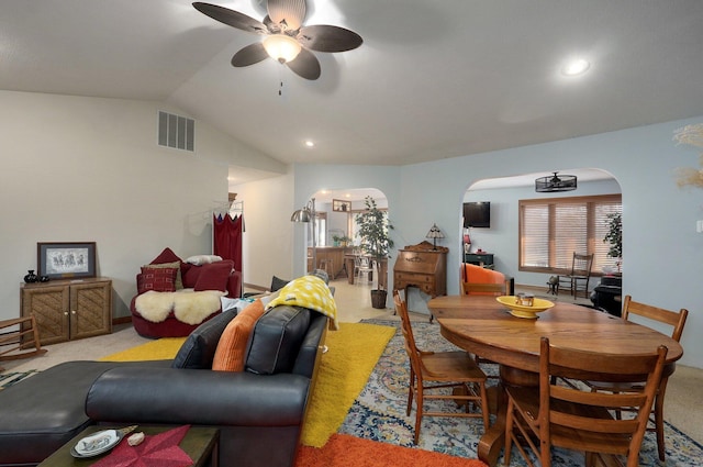 dining space featuring ceiling fan, light carpet, and vaulted ceiling