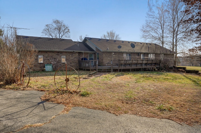 back of property featuring a lawn and a wooden deck