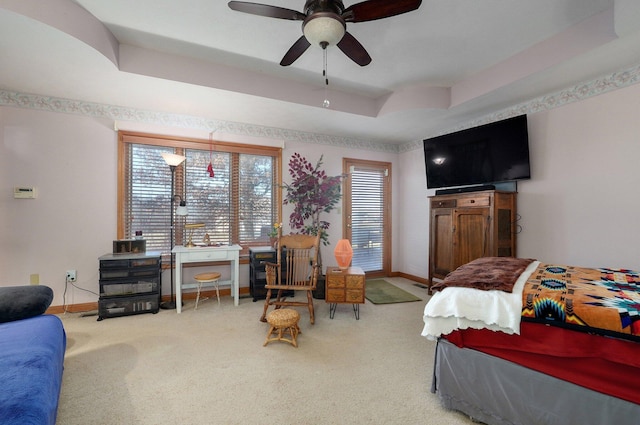 bedroom with carpet, a raised ceiling, and ceiling fan